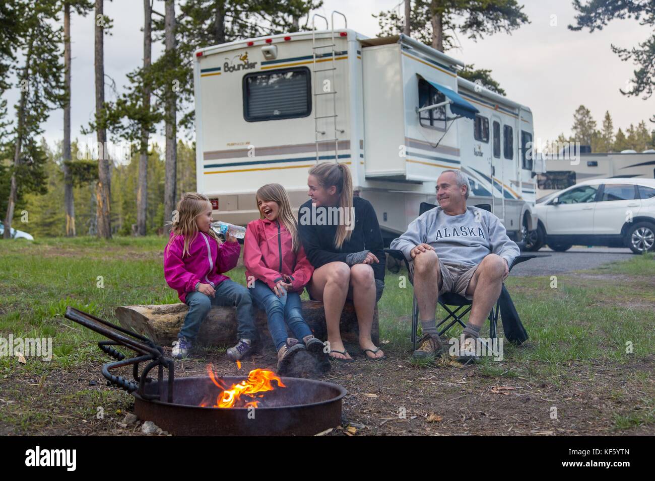 Family in the Norris Camground, with a recreational vehicle, laughing and sitting around a campfire, Yellowstone National Park, Wyoming, June, 2016. Image courtesy Neal Herbert/Yellowstone National Park. Stock Photo