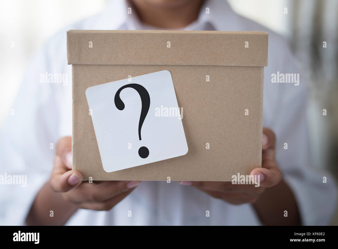 young boy holding a box with white note question mark. whats in the box