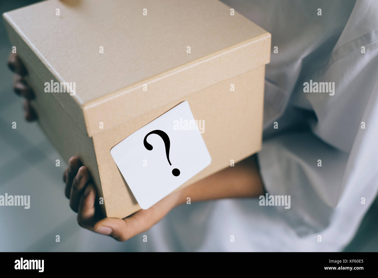 young boy holding a box with white note question mark. whats in the box