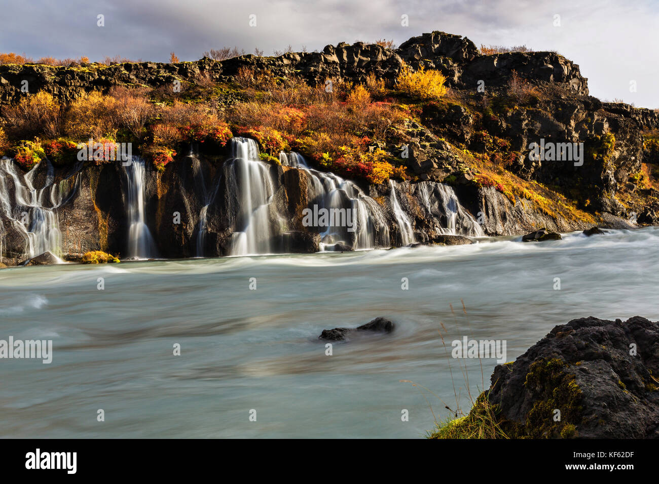 Hraunfossar (Borgarfjörður, western Iceland) is a series of waterfalls formed by rivulets streaming over a distance of about 900 metres out of the Hal Stock Photo