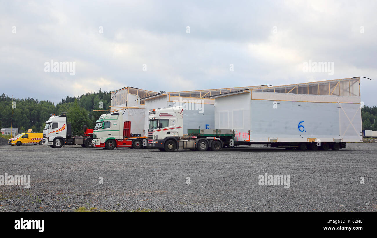 FORSSA, FINLAND - AUGUST 10, 2017: Three oversize load transports of prefabricated house modules, hauled by M. Kaleva, are parked on a truck stop yard Stock Photo