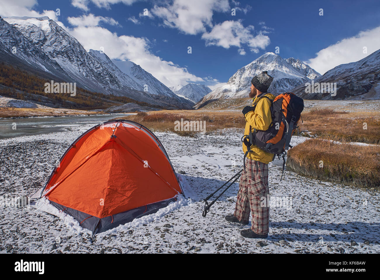 Hiker with backpack at camping in the mountains during springtime. Stock Photo