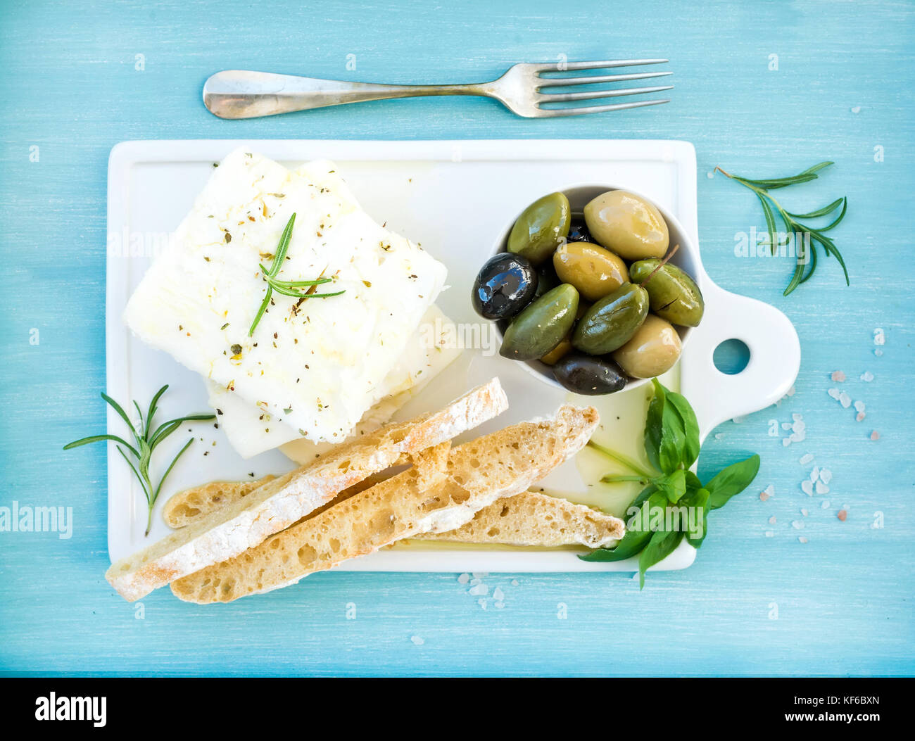Fresh feta cheese with olives, basil, rosemary and bread slices Stock