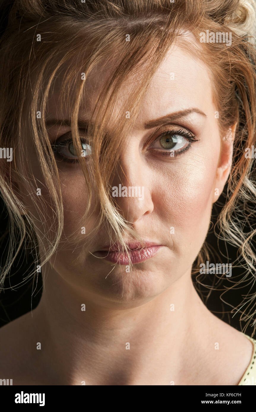 Serious mature woman hair covering face staring Stock Photo