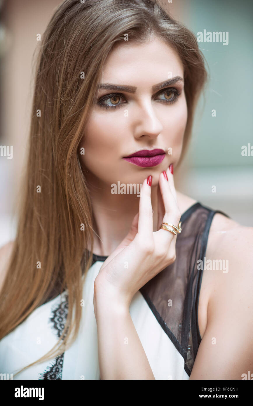 Beautiful young woman hand touching face looking away outdoors Stock ...
