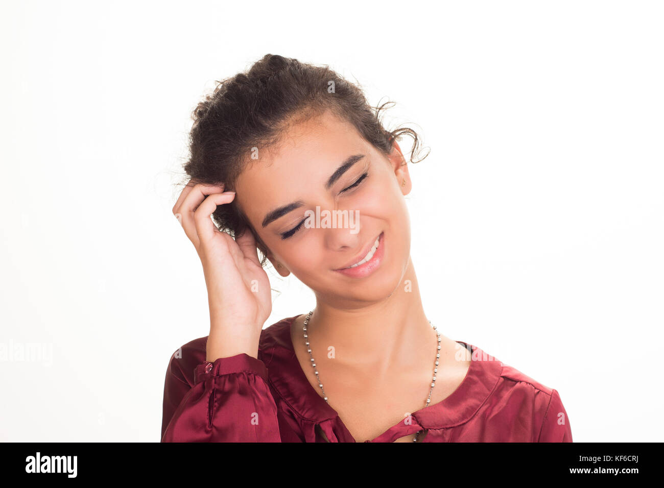 Young woman scratching her head against a white background Stock Photo