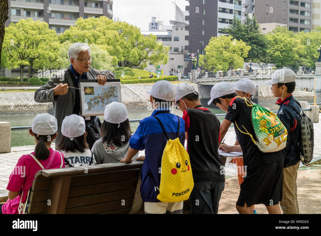 Hiroshima, Japan - May 25, 2017: Volunteer teacher is telling a group of  students about the history of the A bomb in the Hiroshima Peace Memorial Par Stock Photo