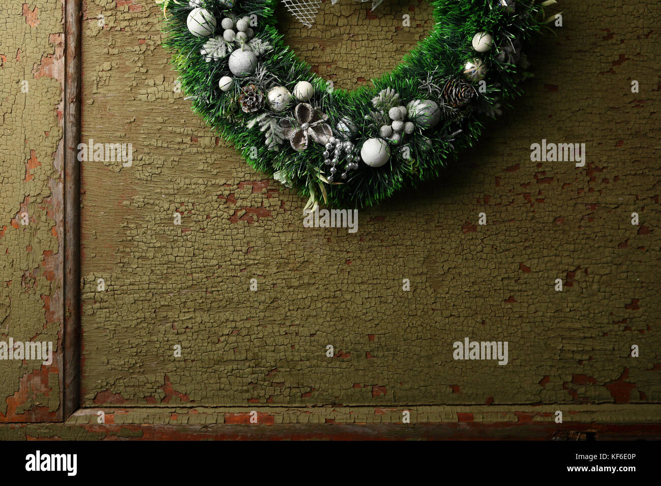 Green Christmas wreath on green door, holiday background Stock Photo