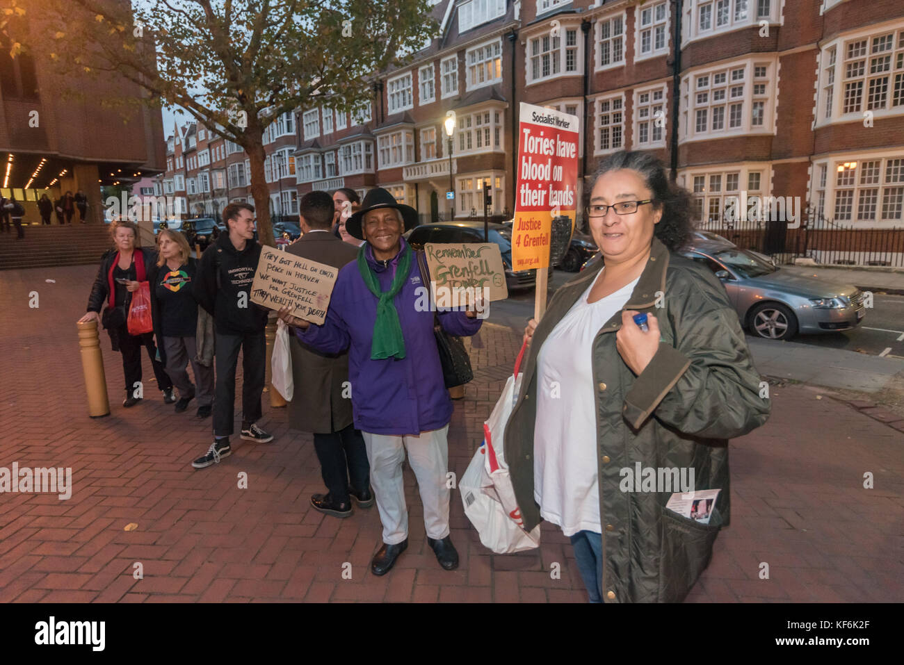 London, UK. 25th Oct,  2017. Protesters outside the Royal Borough of Kensington & Chelsea council meeting holds posters about Grenfell Tower including one reading 'They Got Hell On Earth - Peace in Heaven - We want Justice for Grenfell - They Wealth Your Death'. Others protesting included Class War which has strong links with the area. Credit: Peter Marshall/Alamy Live News Stock Photo