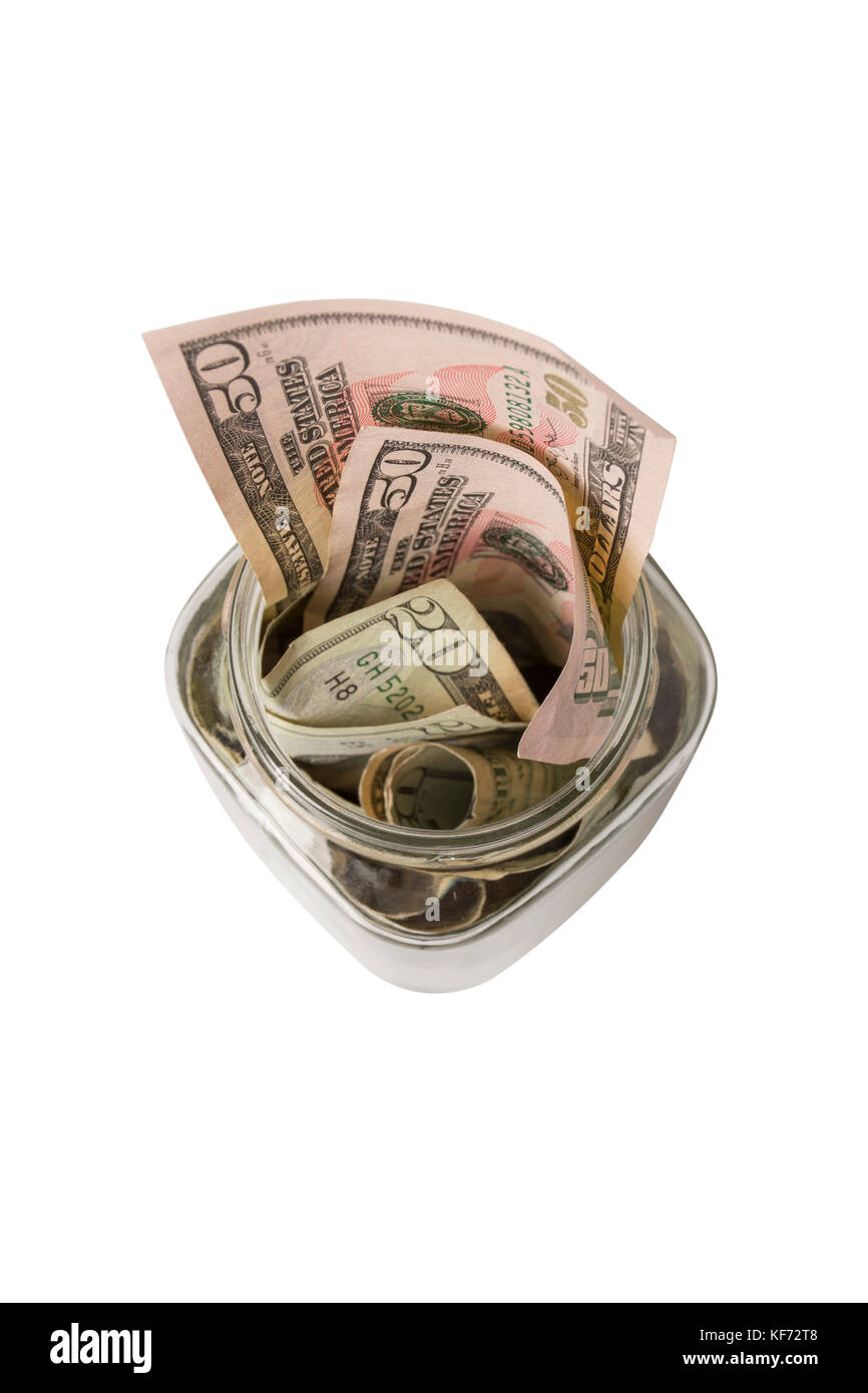 Overhead view of a small glass tip jar or donation jar stuffed with American fifty and twenty dollar bills, isolated on white Stock Photo