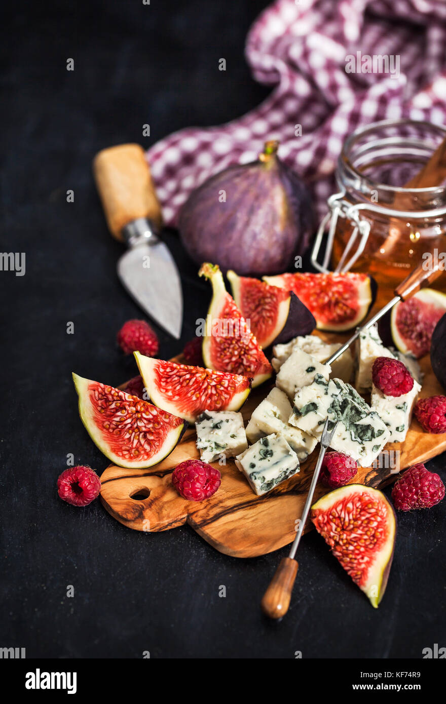 Appetizer plate with blue cheese, fresh figs, raspberries and honey on
