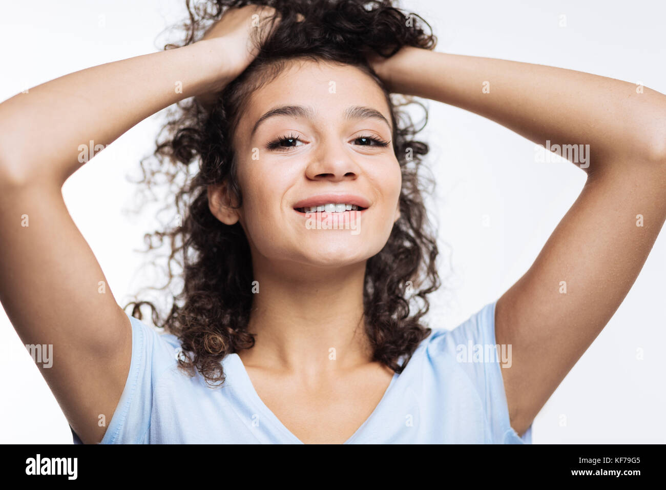 Close up of curly woman lifting up her hair Stock Photo