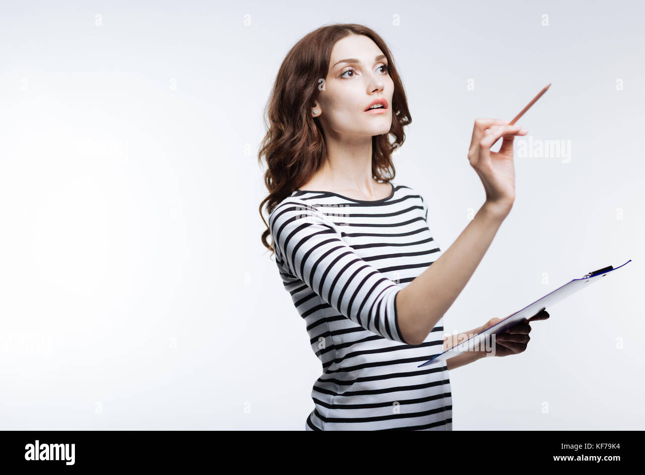 Inspired woman holding pencil and sheet holder Stock Photo - Alamy