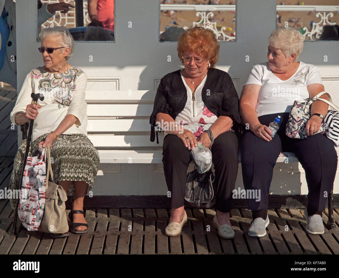 Old Ladies Enjoy Sitting Down In A Sunny Spot On Brighton Pier Stock Photo Alamy