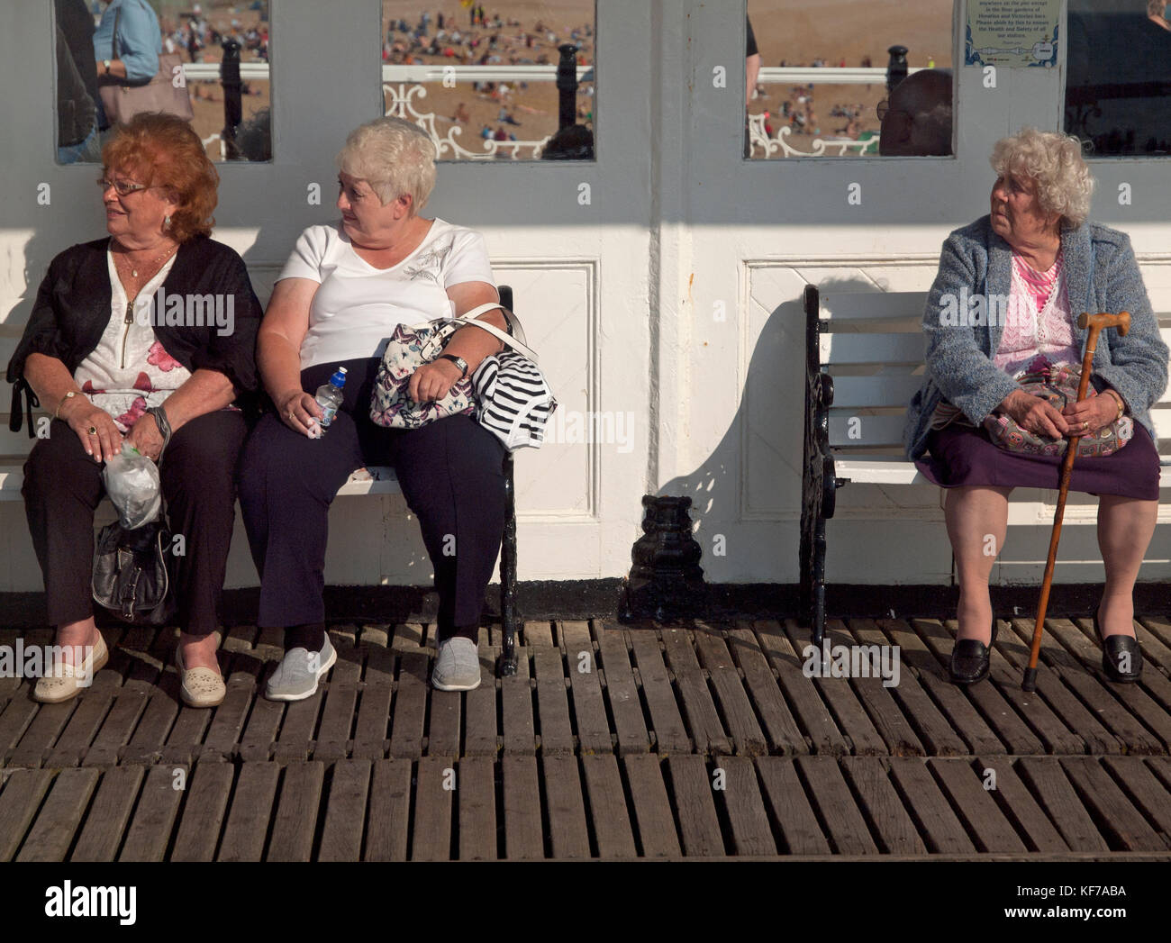 Old Ladies Enjoy Sitting Down In A Sunny Spot On Brighton Pier Stock Photo Alamy
