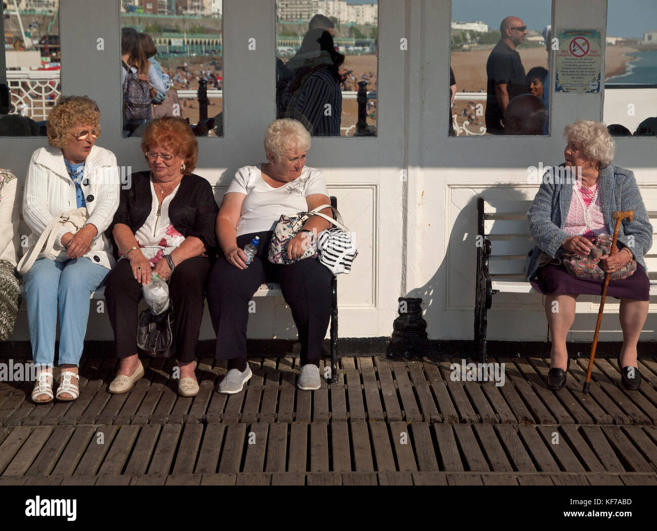 Old Ladies Enjoy Sitting Down In A Sunny Spot On Brighton Pier Stock Photo Alamy