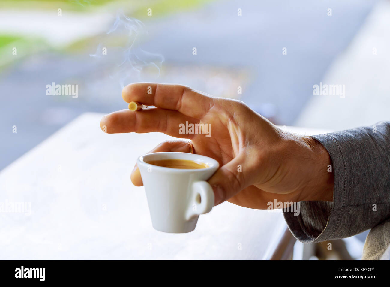 Cigarette in Male Hand With a Cup of Coffee. Smoking Addiction Concept