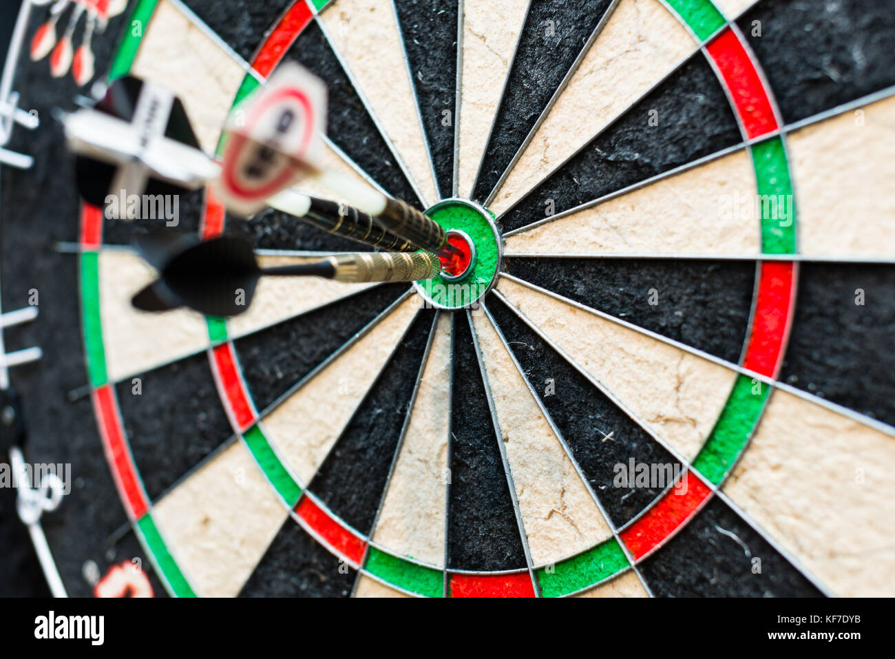 Dart board with three darts in bullseye Stock Photo - Alamy