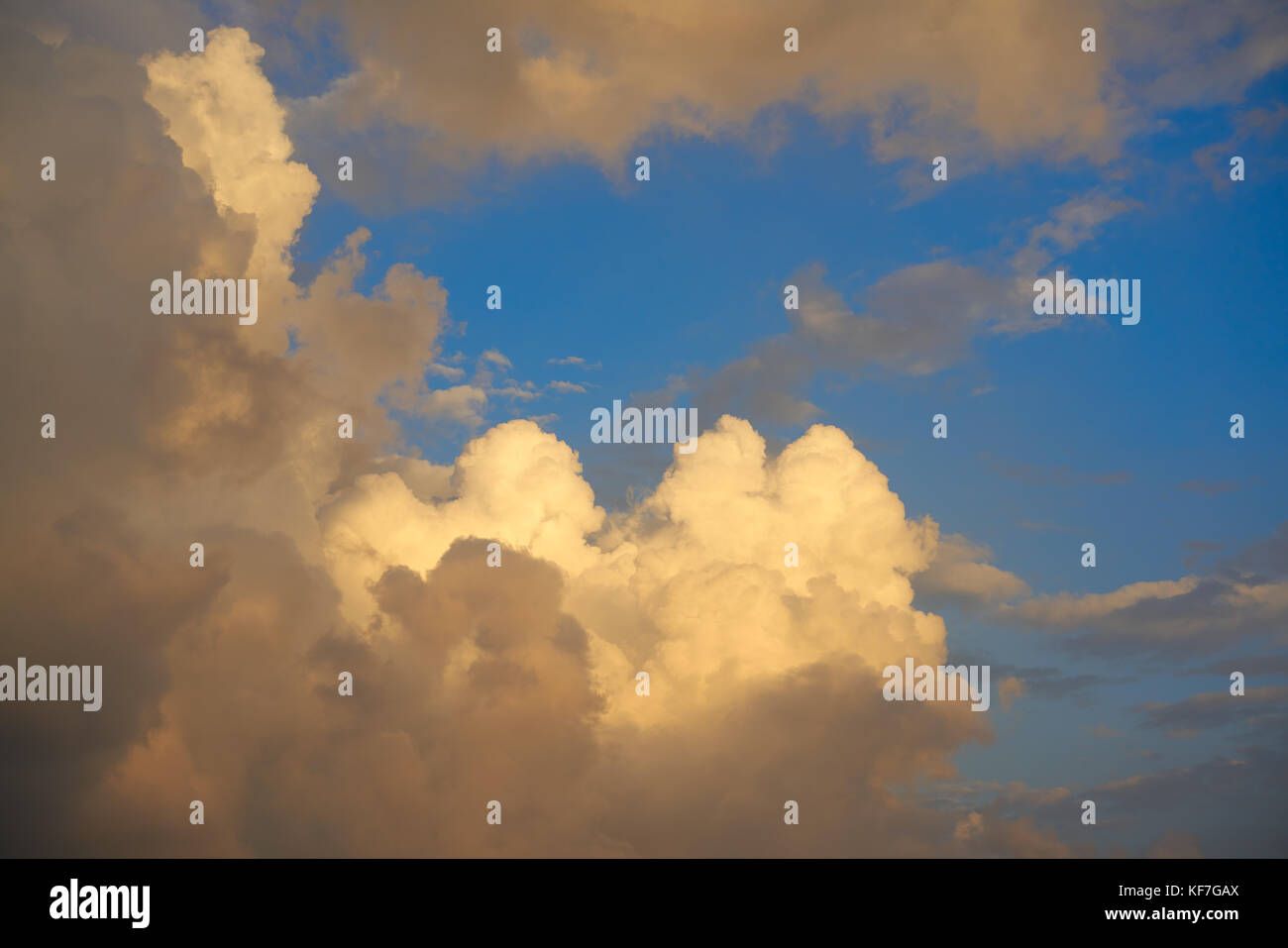 Blue sunset sky golden cumulus clouds background Stock Photo - Alamy