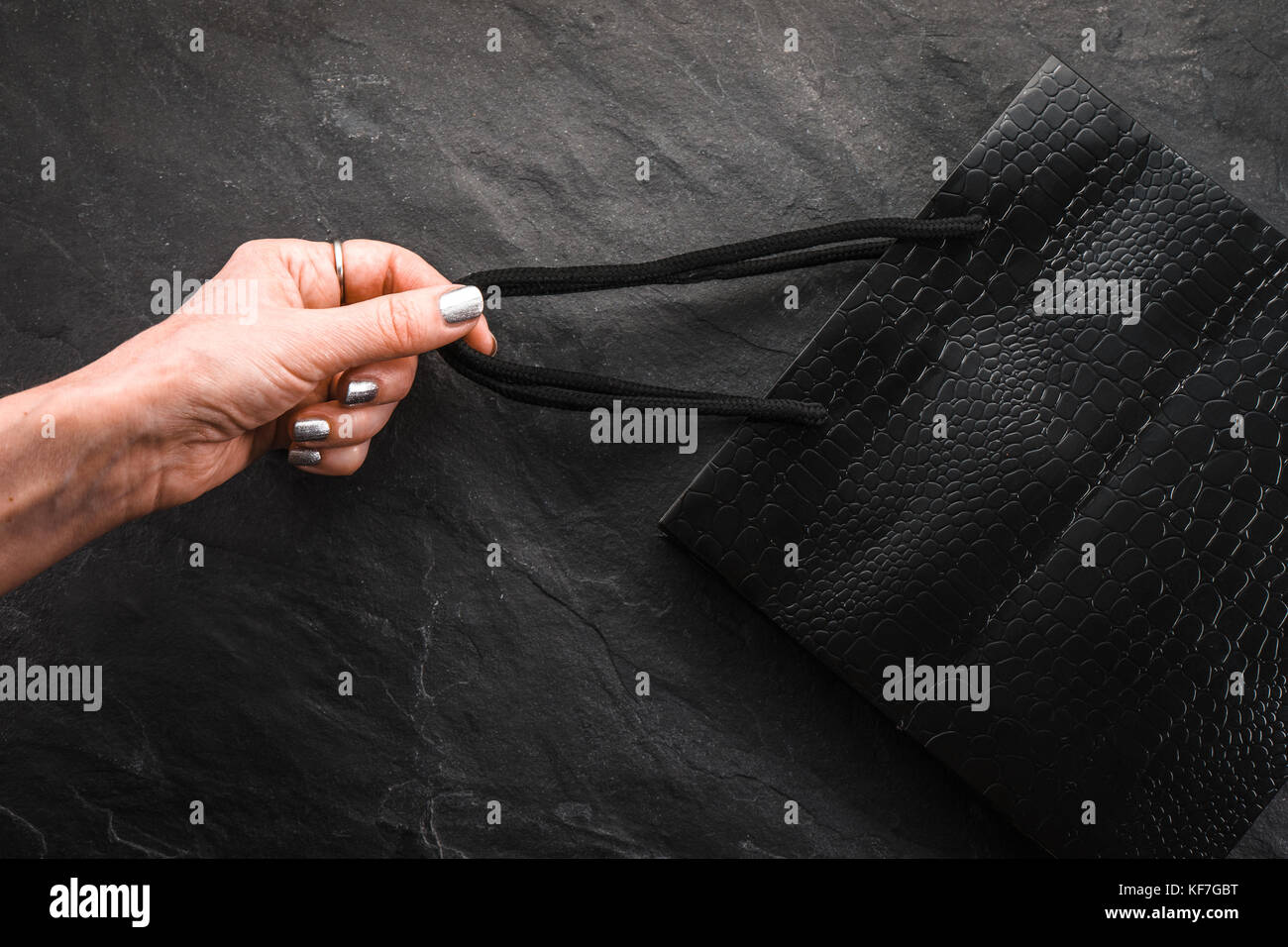 Female hand pulls a black package for a tape, a sale horizontal Stock Photo