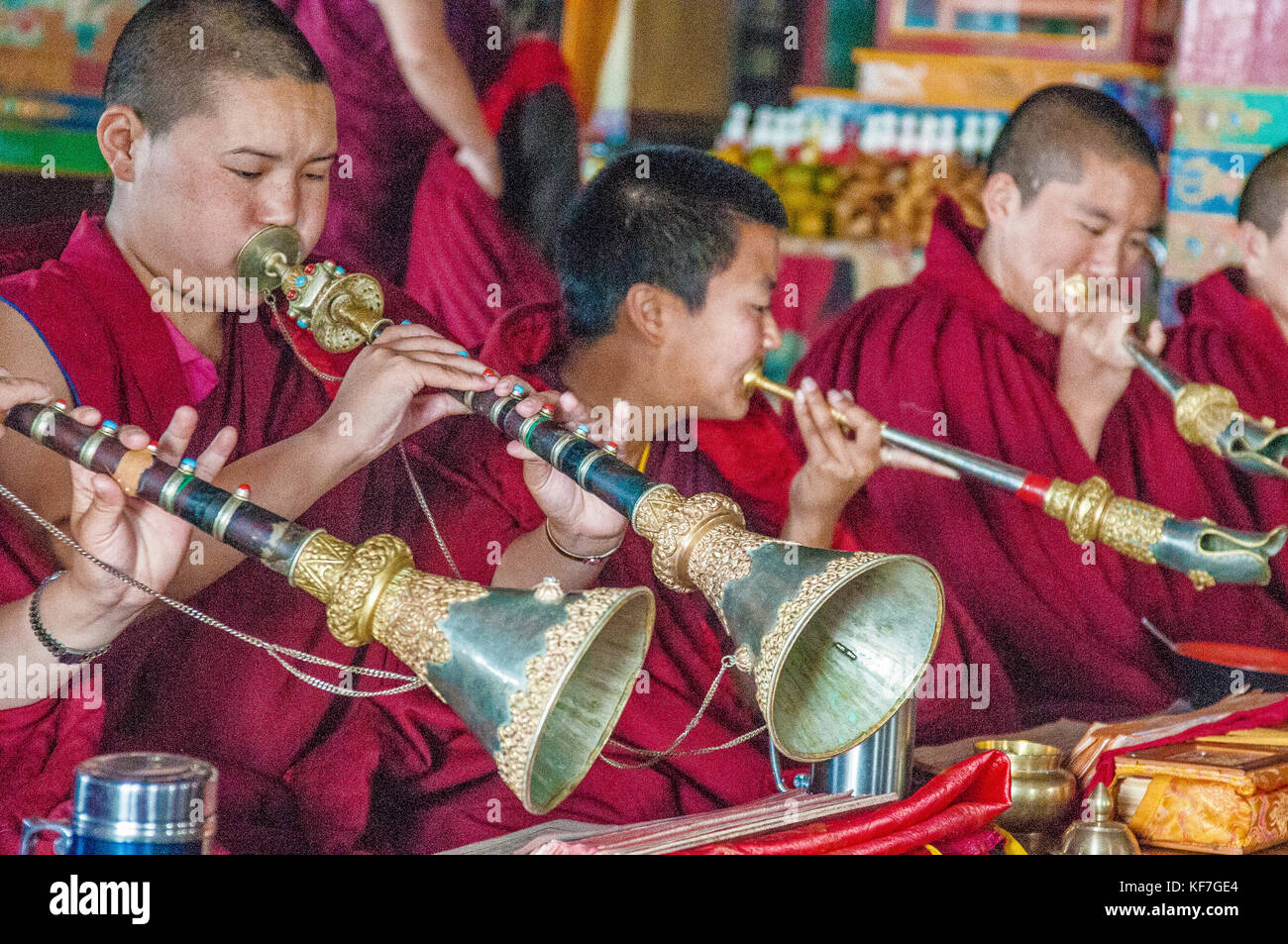 Buddhist monks blow the Tibetan horn or dungchen at Ani Gumba, a Sherpa Buddhist monastery inside Shivapuri National Park, Nepal Stock Photo