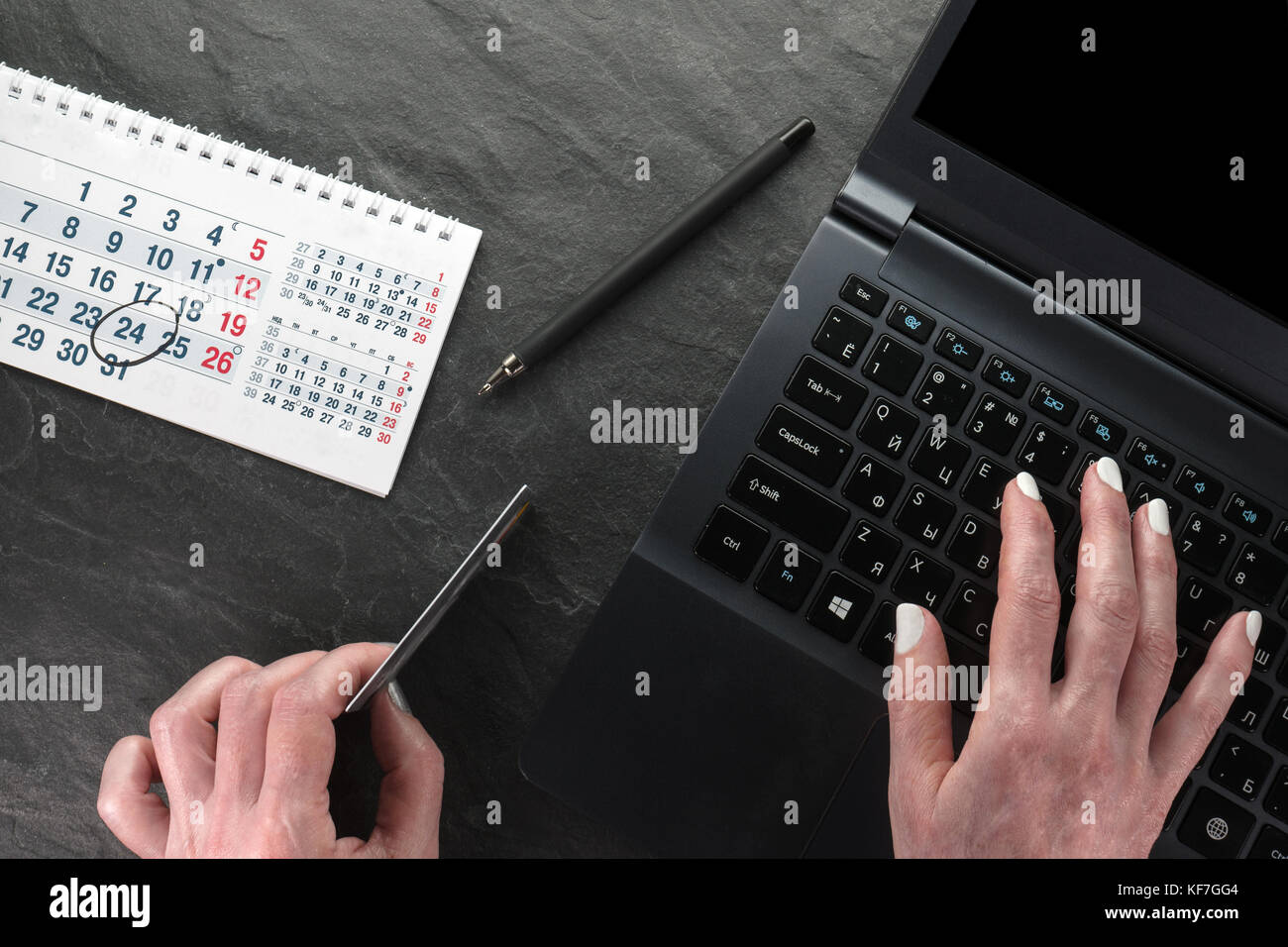 Computer, plastic card and hands, calendar, black Friday close-up horizontal Stock Photo