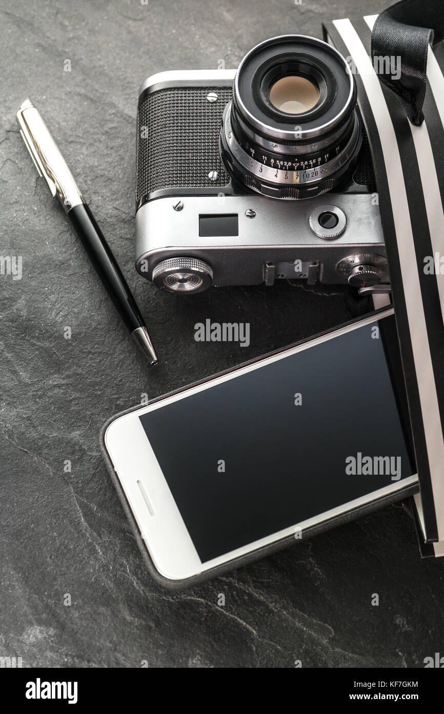 Phone, camera, pen in a black bag with white stripes close-up vertical Stock Photo