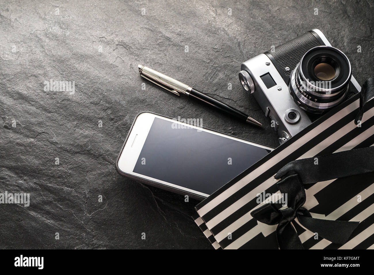 Phone, camera, pen in a black bag with white strips free space horizontal Stock Photo