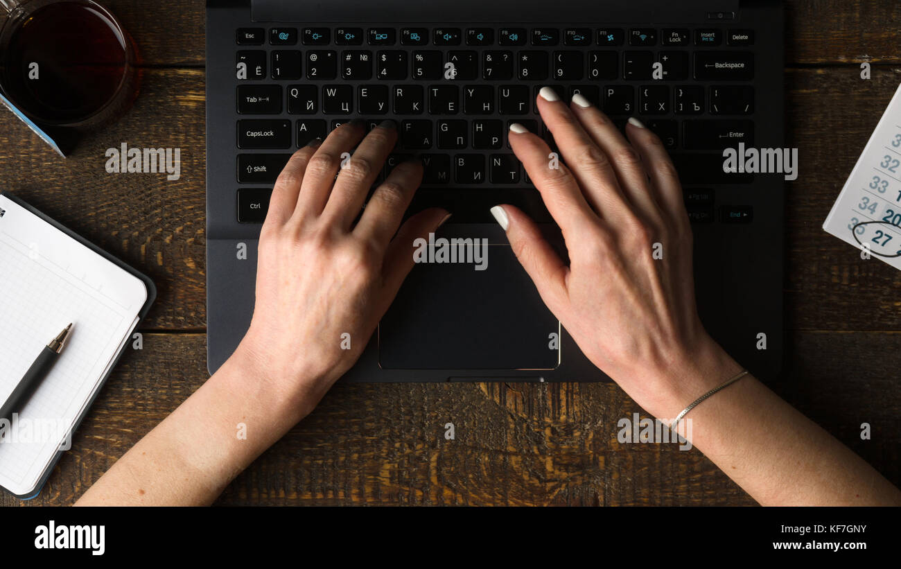 Hands on computer keyboard, notebook and pen view from above horizontal Stock Photo