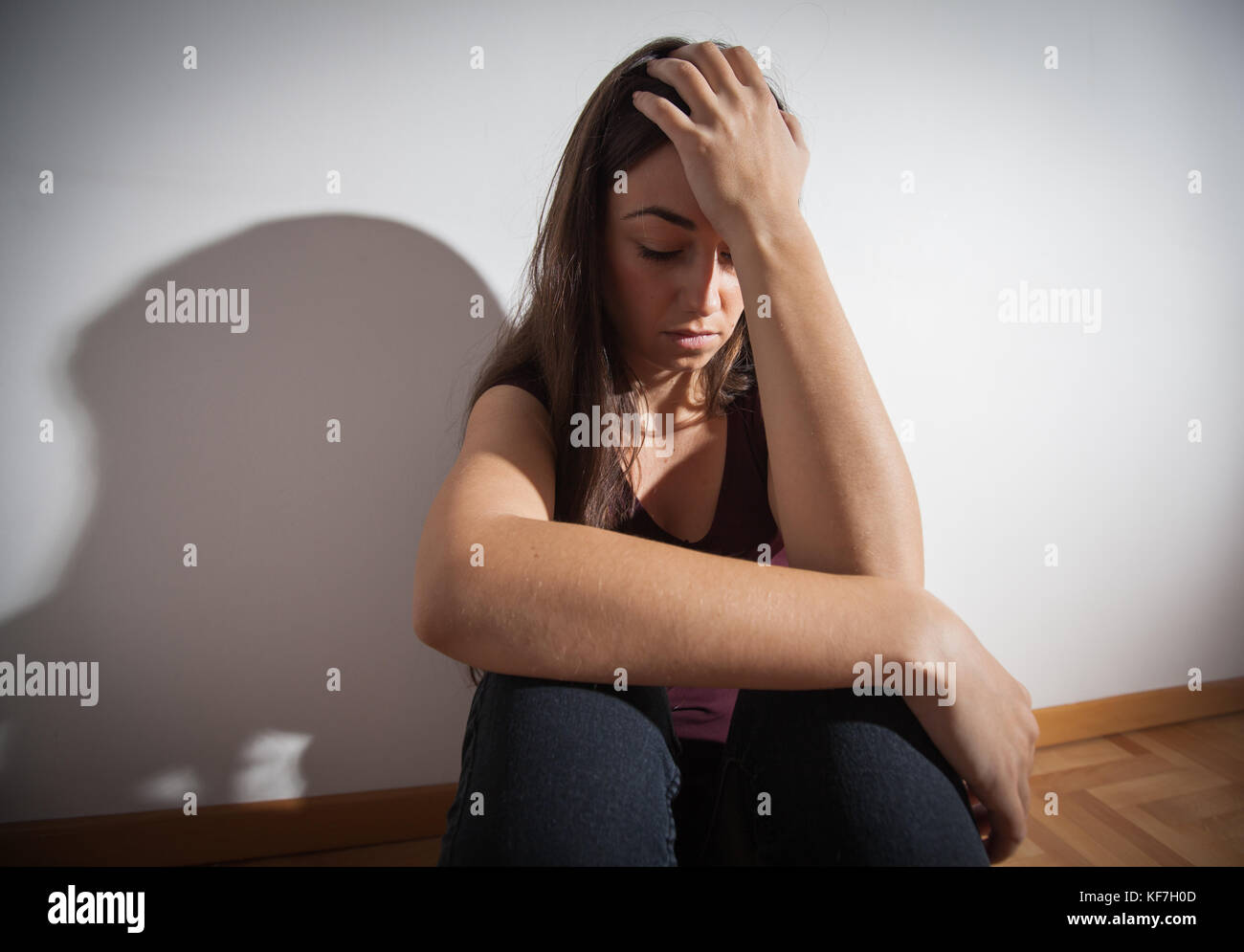 Depressed young woman sitting on floor in empty room,sad depression ...