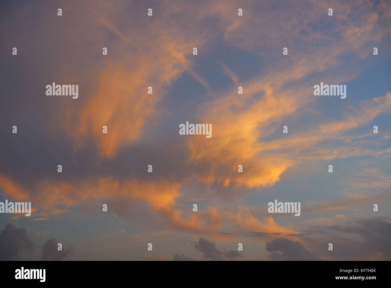 Sunset sky with orange golden clouds on blue background Stock Photo - Alamy