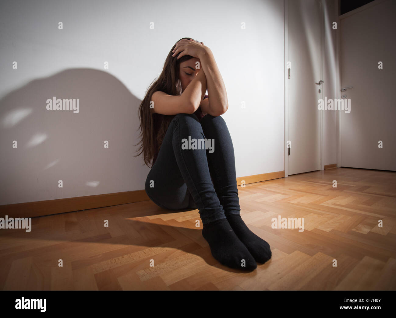 Depressed young woman sitting on floor in empty room,sad depression ...