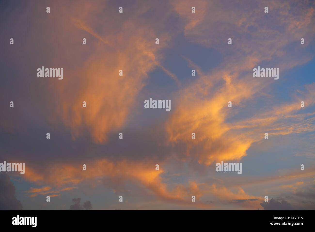 Sunset sky with orange golden clouds on blue background Stock Photo - Alamy