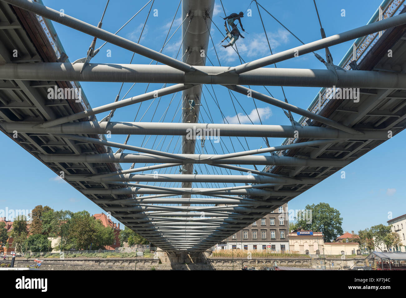 KRAKOW, POLAND-AUGUST 8, 2017: Krakow's Father Bernatek footbridge.The nine acrobatic figures form the exhibition entitled Between the water and the s Stock Photo