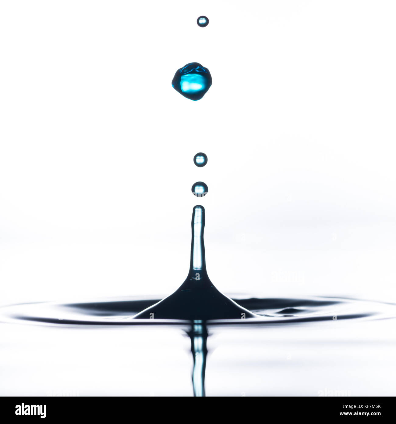 An abstract macro shot of water drops falling into a pool of water