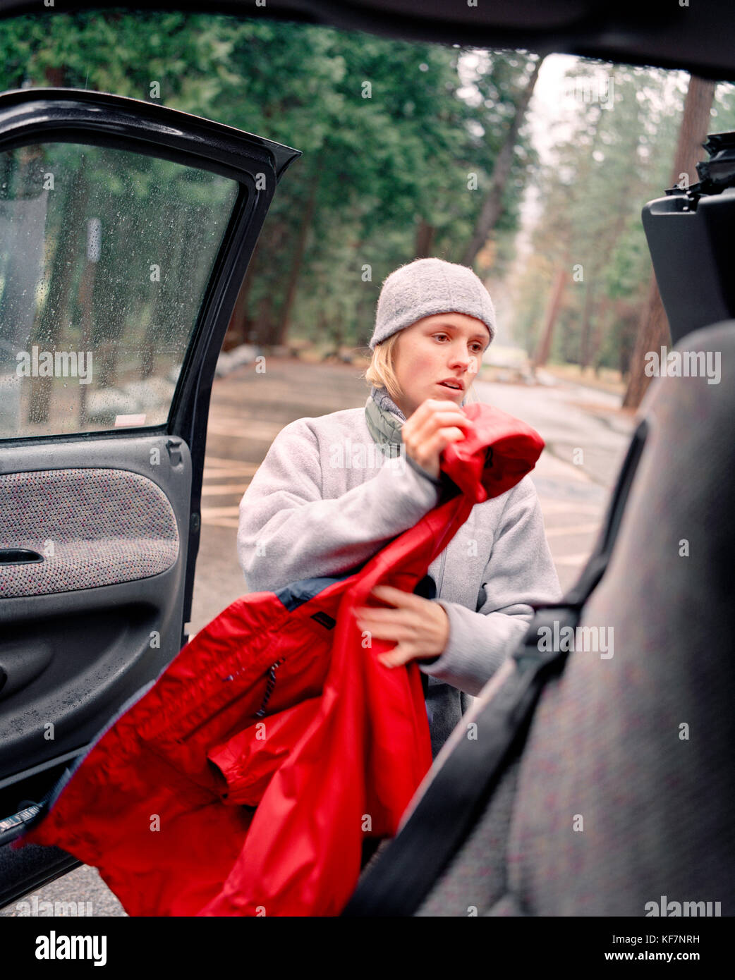 USA, California, Yosemite National Park, a young woman prepares to go hiking in the rain Stock Photo
