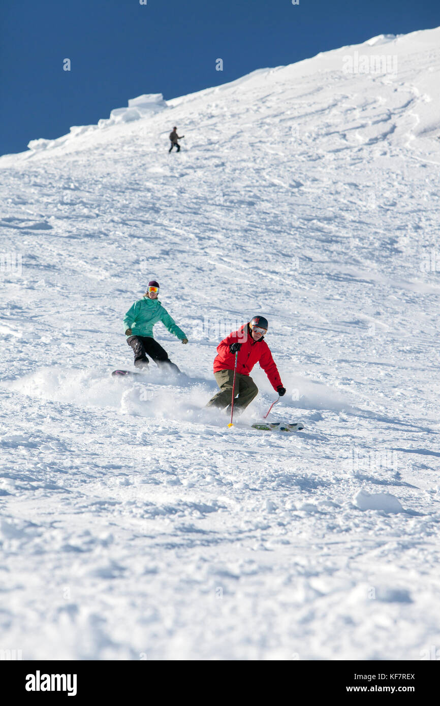 USA, California, Mammoth, a skier and boarder enjoying the fresh powder turns at Mammoth Ski Resort Stock Photo