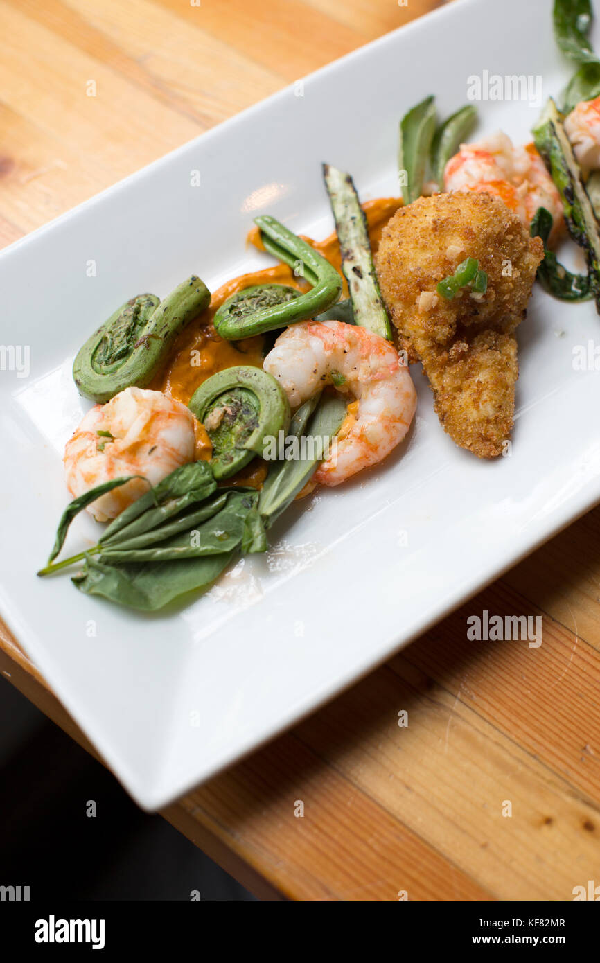 CANADA, Vancouver, British Columbia, shrimp and fiddlehead ferns are served at a local bistro, Edible Canada, located on Granville Island Stock Photo