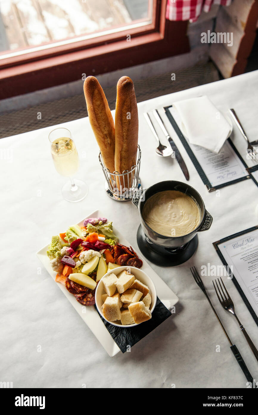 USA, Colorado, Aspen, table setting with cheese fondue and champagne at the Cloud Nine Restaurant, Aspen Highlands Ski Resort Stock Photo