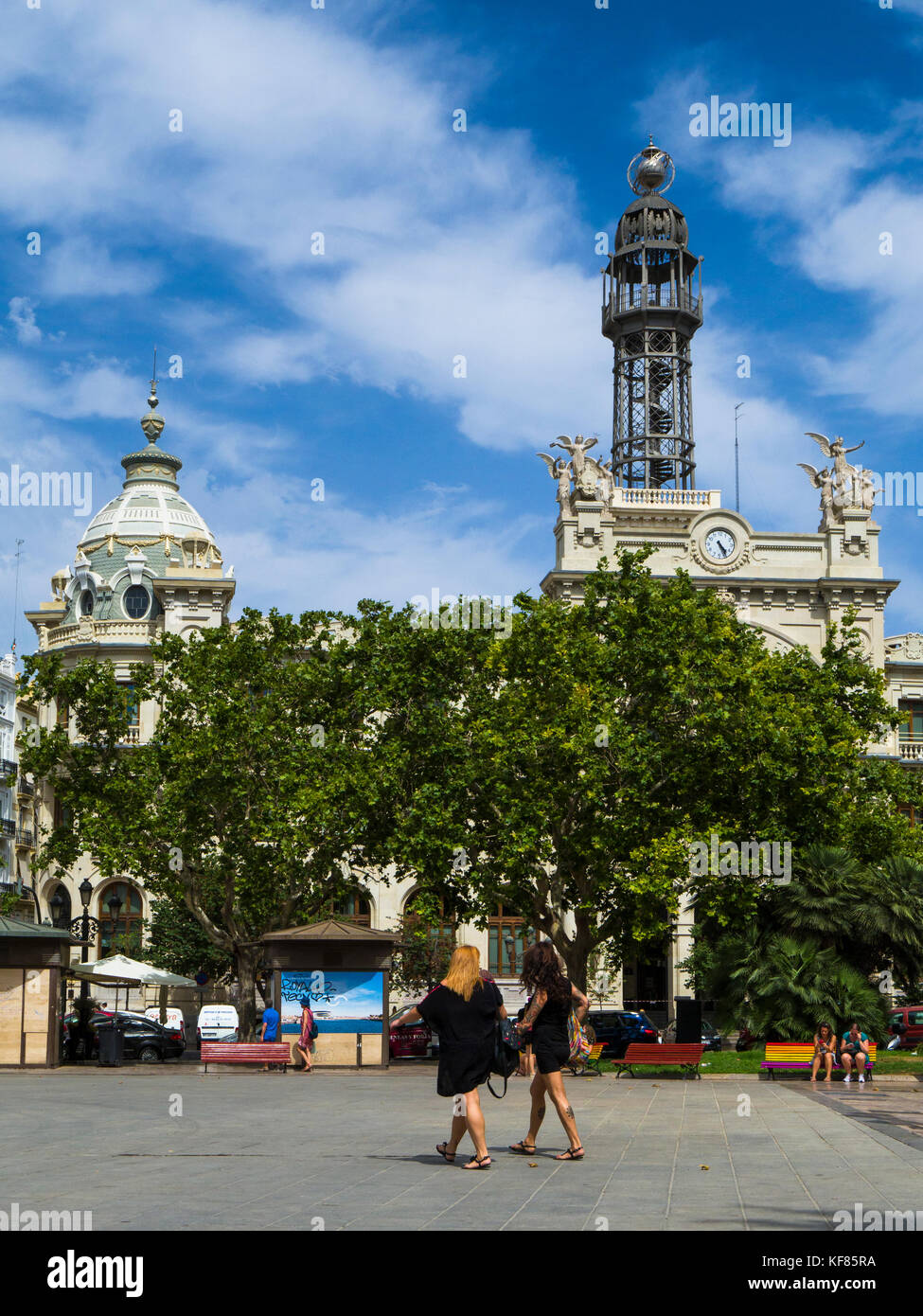 Two women walking across Town Hall Square (Plaza del Ayuntamiento) with the Central Post Office (Correos) in the background, Valencia, Spain Stock Photo