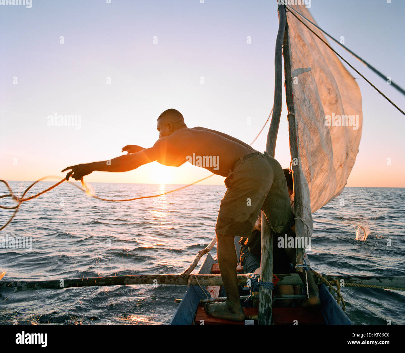 MADAGASCAR, man in pirogue throwing rope, Indian Ocean, Anjajavy Stock ...