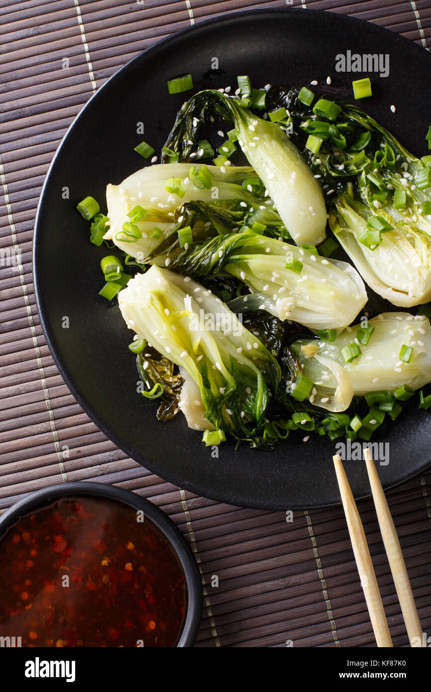 stirfry spicy baby bok choy closeup on a plate. Vertical top view