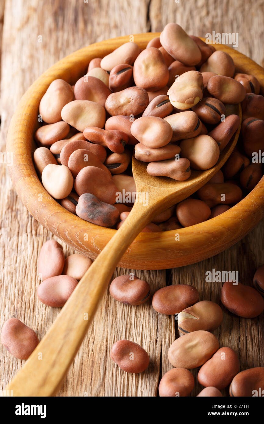 Dried healthy broad beans close-up in a wooden bowl on the table. vertical background Stock Photo