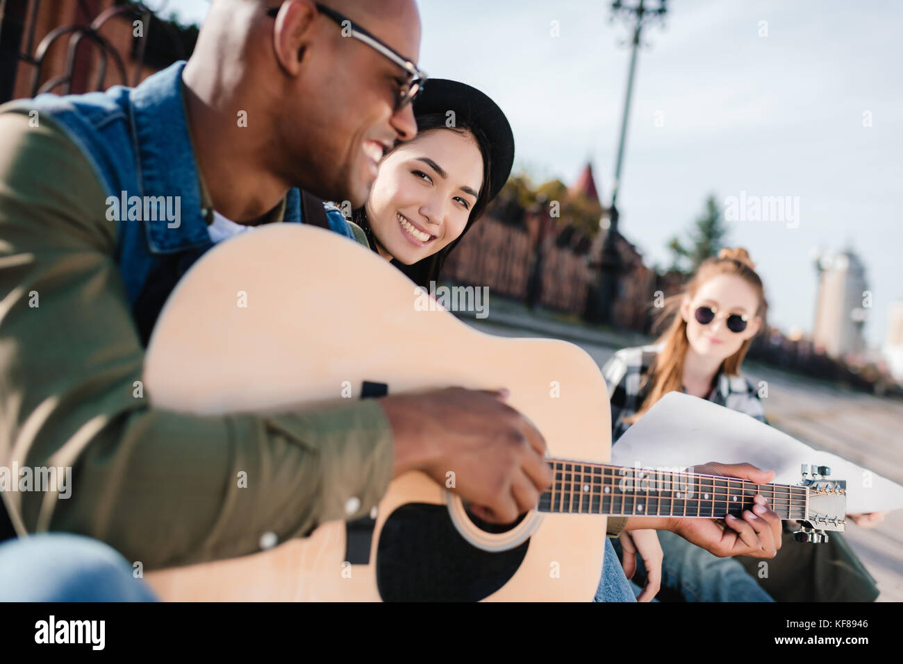 multicultural friends with guitar Stock Photo - Alamy