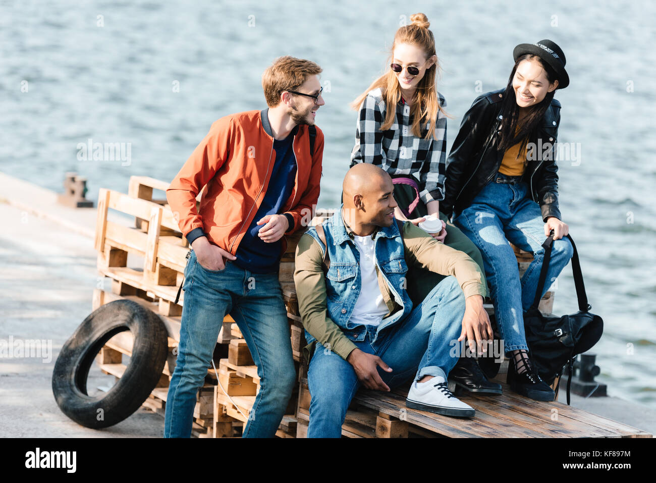 multicultural friends resting on pier Stock Photo - Alamy