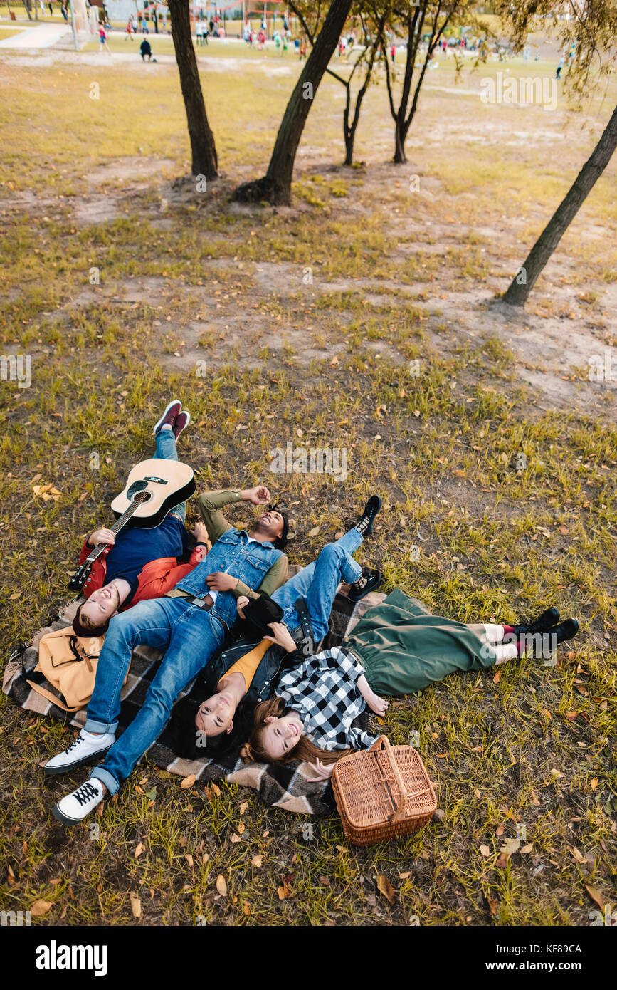 multicultural friends resting on blanket together Stock Photo - Alamy