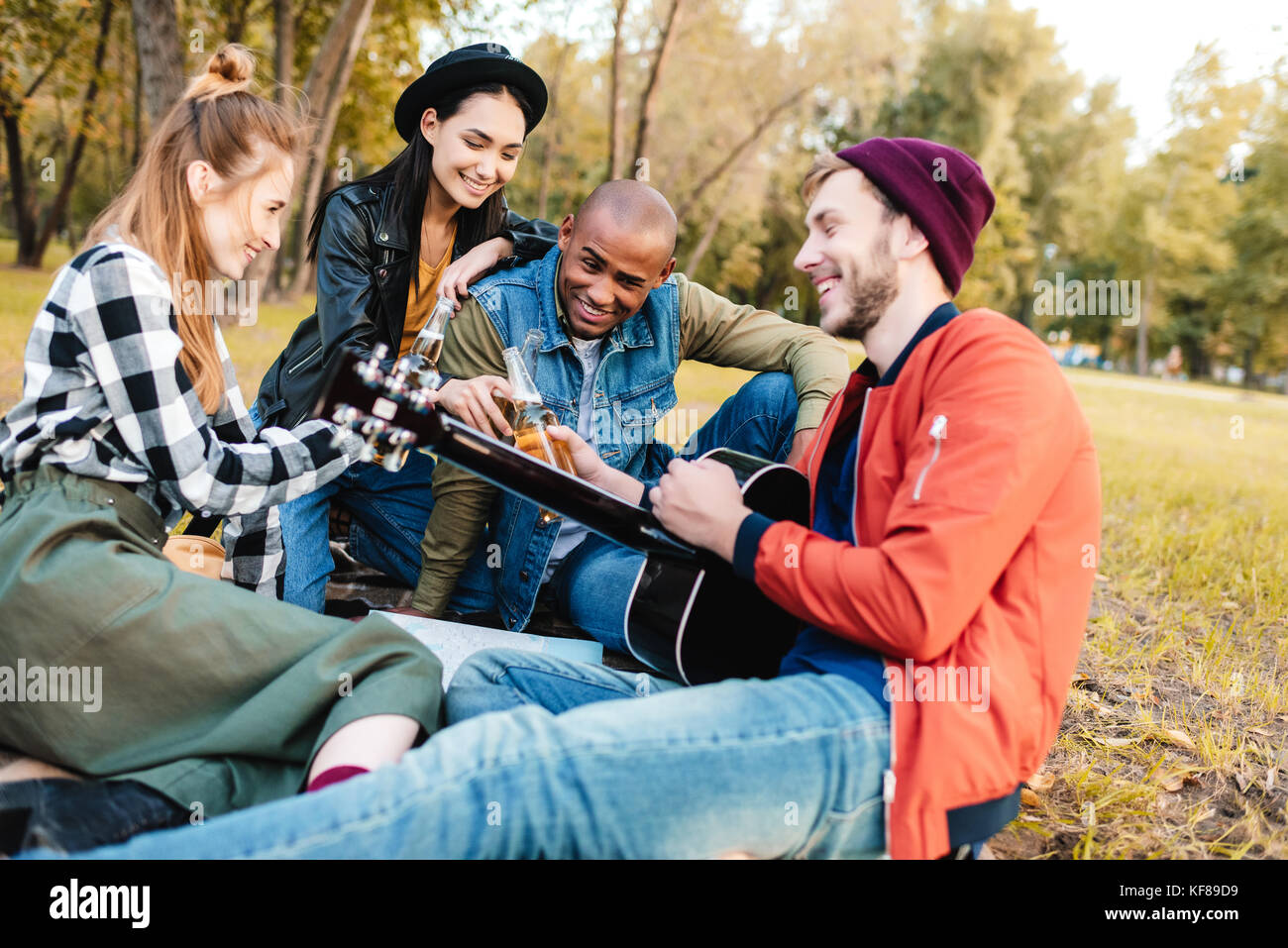 multicultural friends resting in park Stock Photo - Alamy