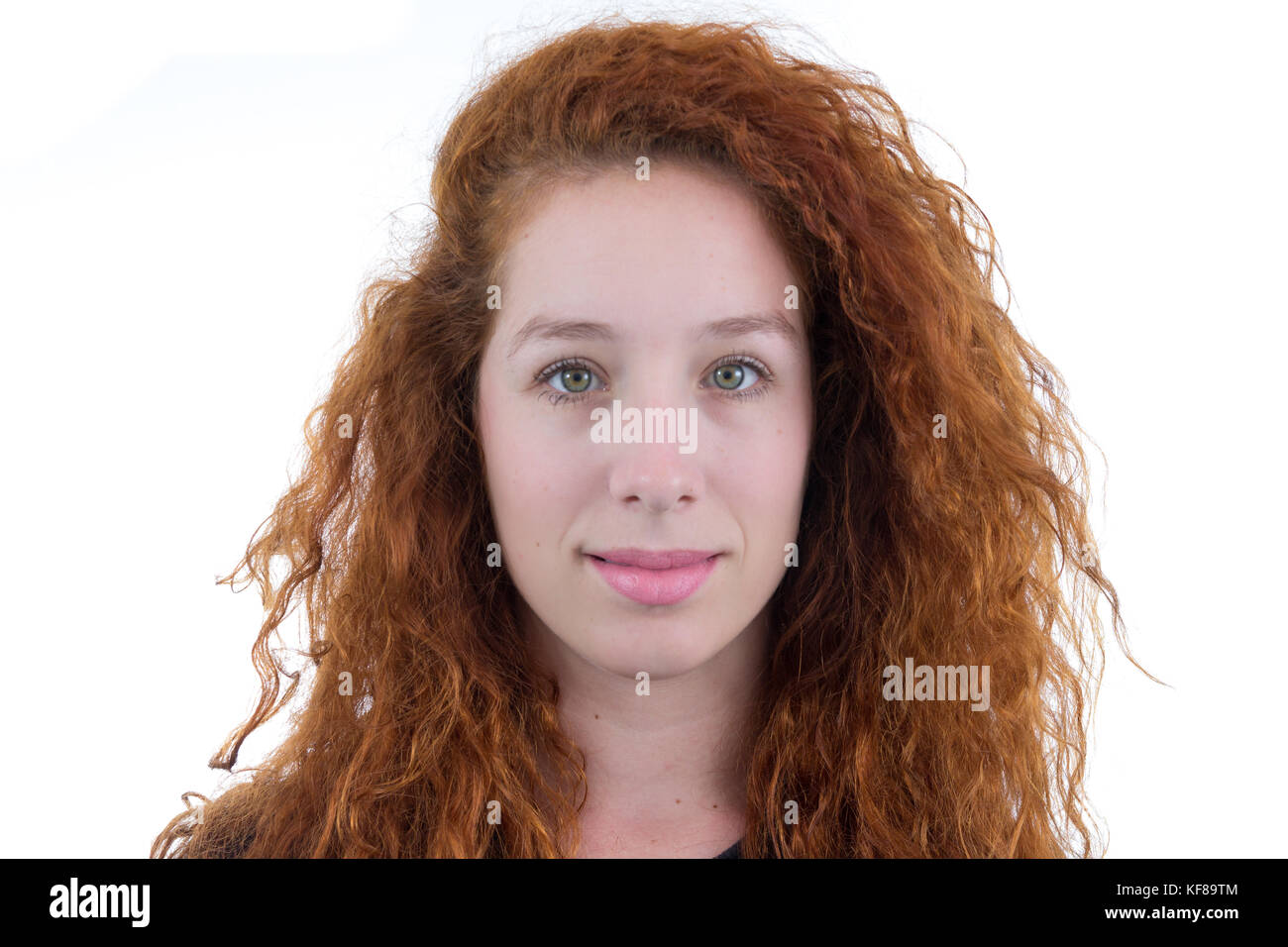 Girl looks at the camera. Shy. The person is redheaded and young. White ...