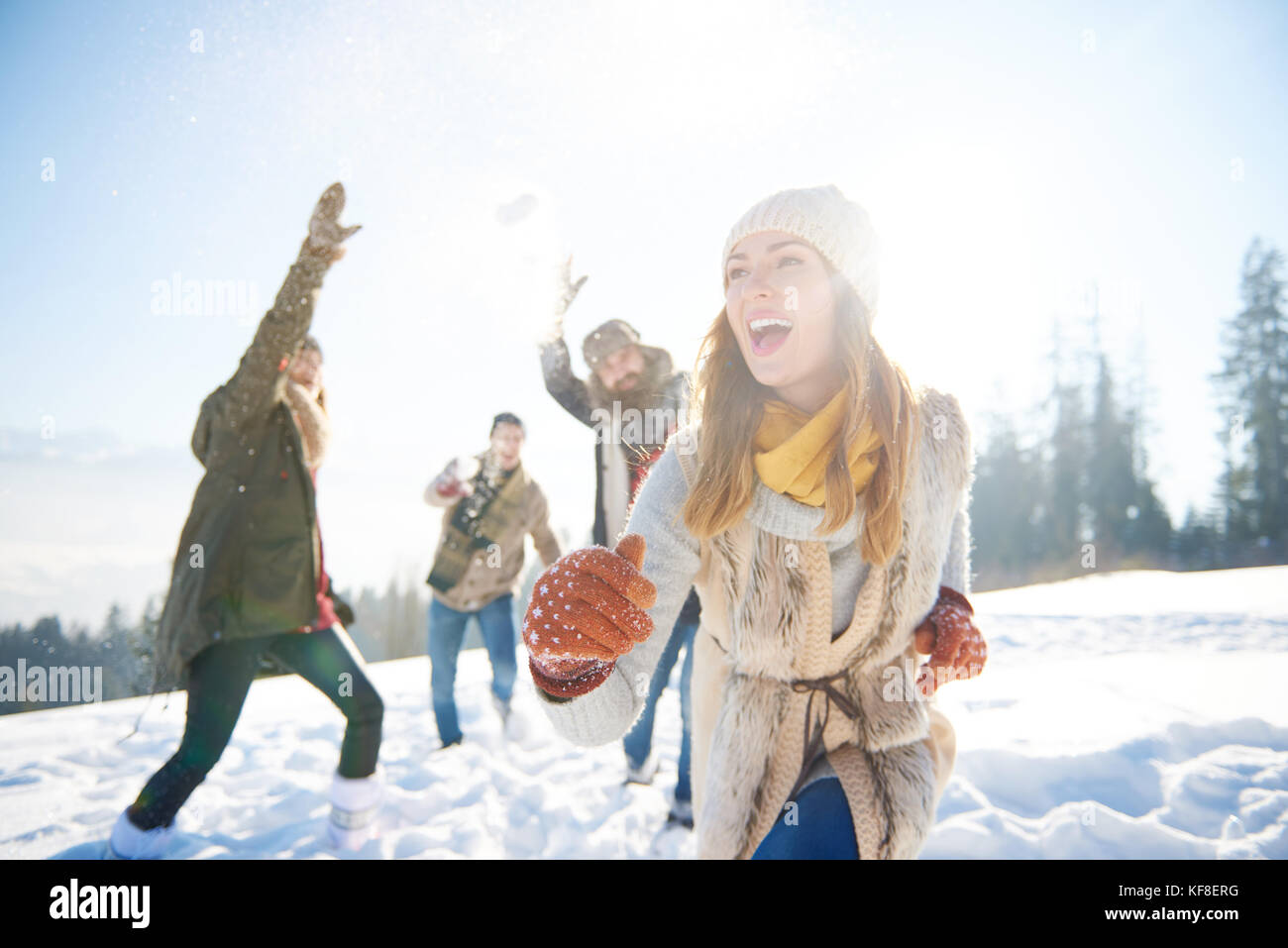 Woman running away from the snow fight Stock Photo