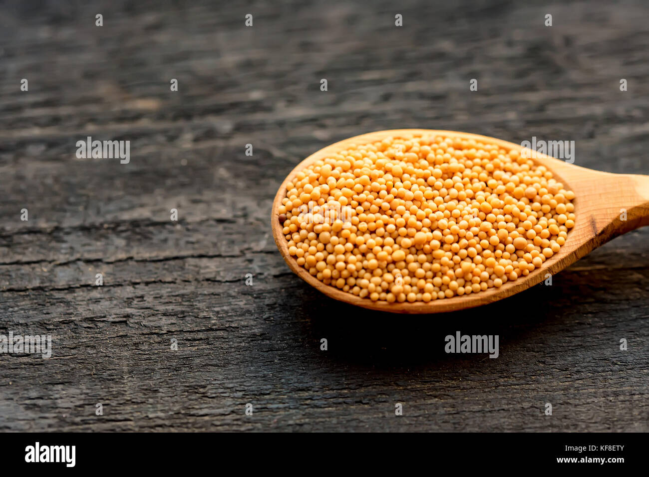 Mustard seeds in wooden spoon close up Stock Photo Alamy